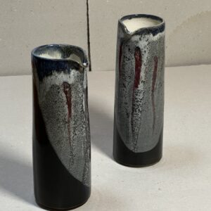 Henkelloser Krug schwarz mit weissen, roten, blauen Einschlüssen